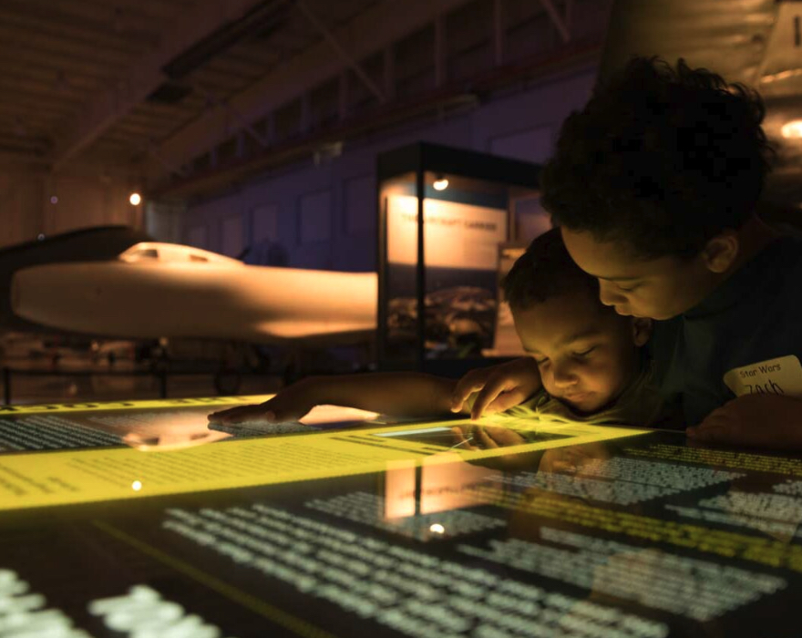 Children exploring information about aviation at the Sullenberger Aviation Museum in Charlotte, NC