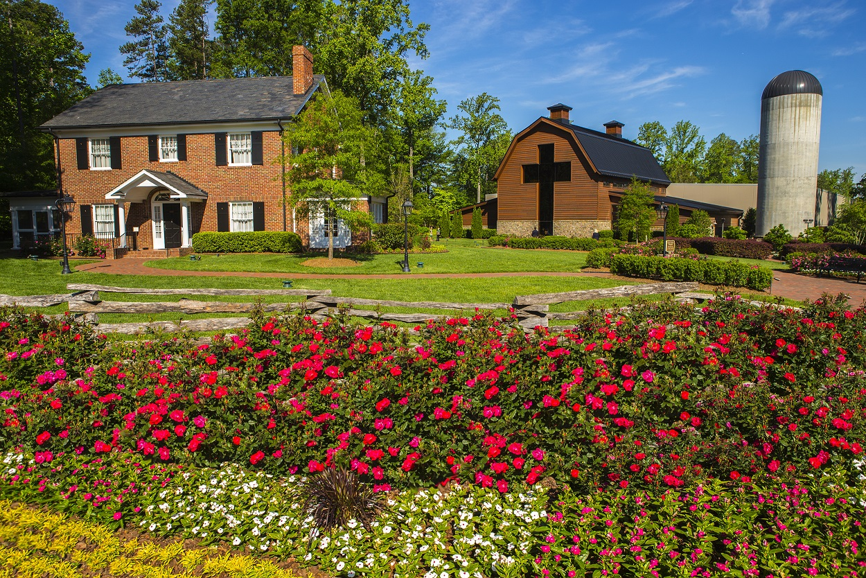 A view of Billy Graham’s Library and childhood home from across a garden of flowers