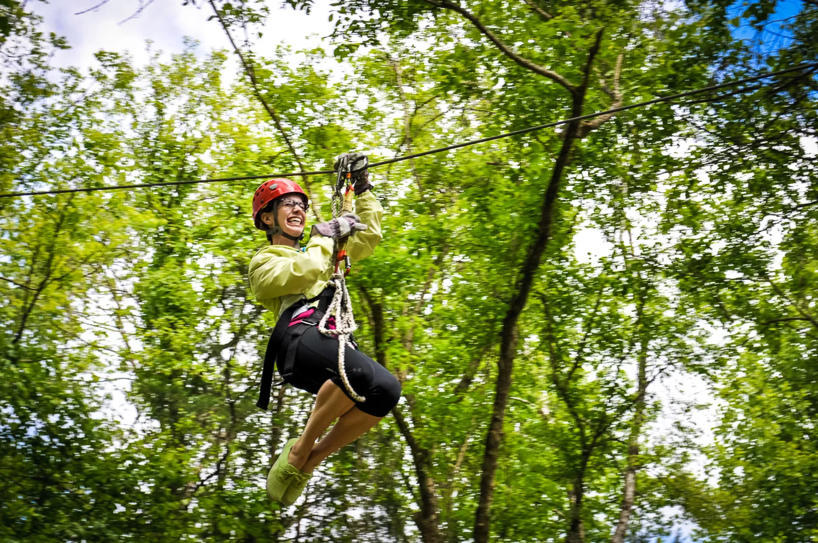 A woman having a thrilling experience in the Canaan Zipline Canopy Tour