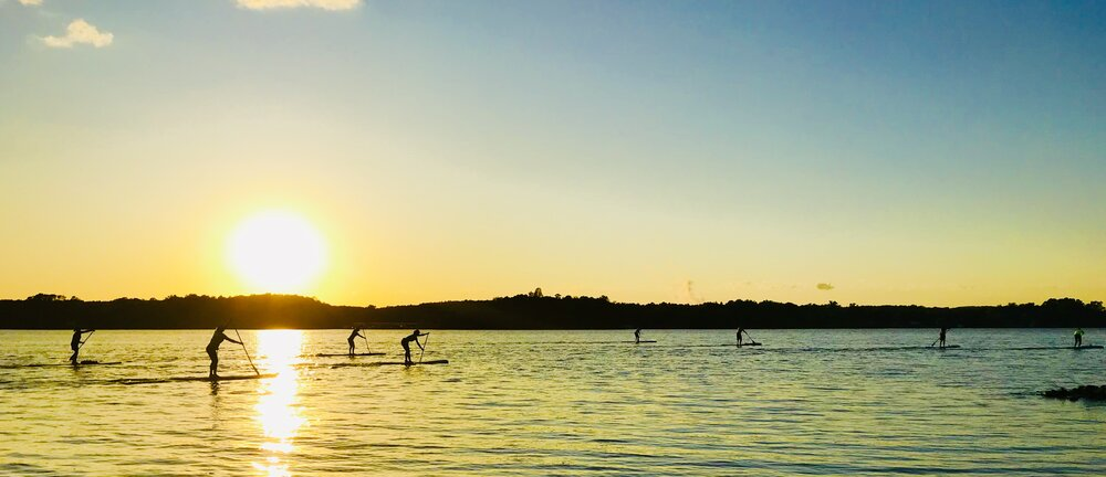 People riding a paddleboard and enjoying the beautiful sunset at Lake Wylie, SC